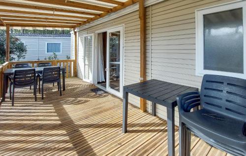 a wooden deck with a table and chairs on it at Nice Stacaravan In Saint-Julien-En-Born in Saint-Julien-en-Born