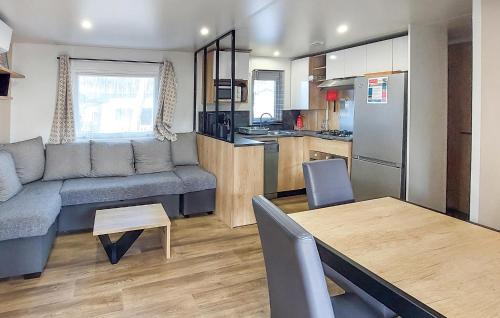 a living room and kitchen with a couch and a table at Nice Stacaravan In Saint-Julien-En-Born in Saint-Julien-en-Born