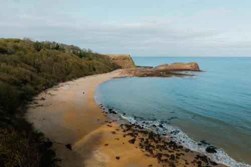 una vista aerea di una spiaggia con alberi e l'oceano di Landal Whitekirk Hill a North Berwick