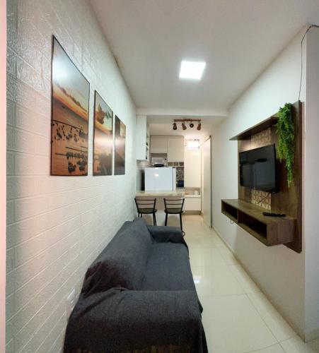 ein Wohnzimmer mit einem Sofa und einem TV in der Unterkunft Apartamento 1/4 Ambiente inteiro in Lauro de Freitas