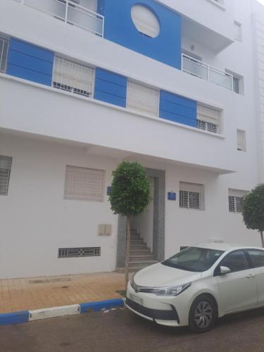 een witte auto geparkeerd voor een gebouw bij HALA Chaouni in Tetouan