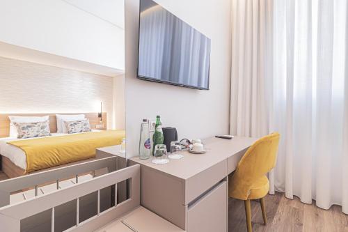 a hotel room with a bed and a desk in a room at Galega Villas in Milharado