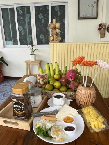 una mesa con un plato de comida y una cesta de fruta en SDHostel, en Don Muang Airport
