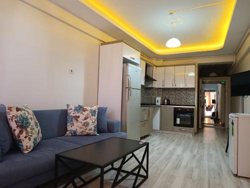 Una sala de estar con un sofá azul y una mesa. en Mir Suit Hotel, en Buca