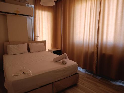 Un dormitorio con una cama con dos pantuflas encima. en Mir Suit Hotel, en Buca