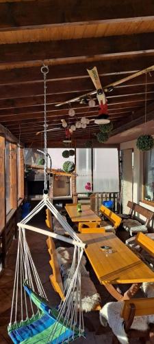 a room with tables and a hammock hanging from the ceiling at Pensiunea MariFlor in Ranca