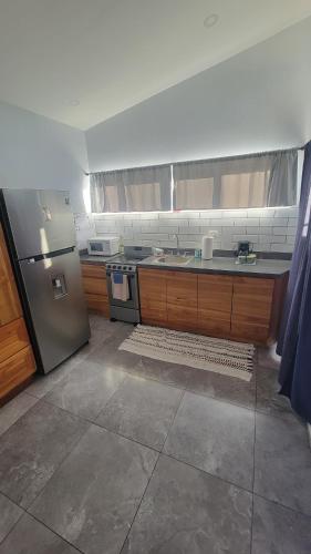 Una cocina con frigorífico de acero inoxidable y fregadero. en Casa Boa Casita Tambor, en La Abuela