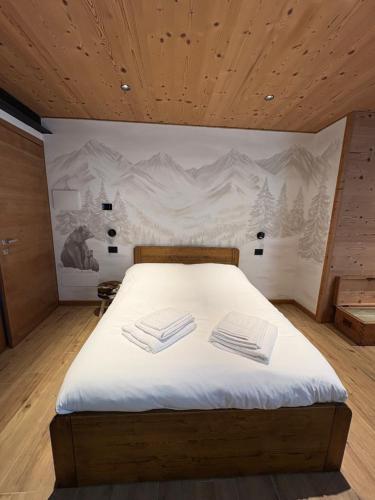 a bedroom with a bed with two towels on it at Cusìcla Affittacamere in Ponte di Legno