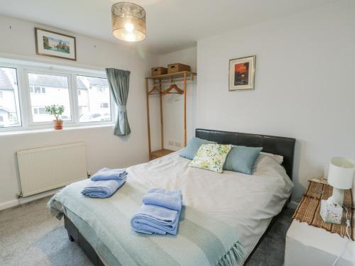 a bedroom with a bed with two towels on it at Hafan Hapus in Beaumaris