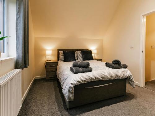 a bedroom with a large bed with two pillows on it at Raven Lodge in Brigg