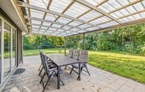 a patio with a table and chairs under a pergola at Gorgeous Home In Farsø With Wifi in Hole