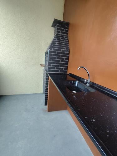 a kitchen with a sink and a brick wall at Pousada Espaço Vista Mar in Itanhaém