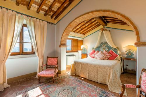 a bedroom with a bed and two chairs at Il Falconiere Relais & Spa in Cortona