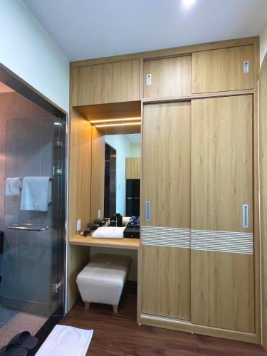 a bathroom with a closet with a desk and a shower at Uberzen Residence Hotel in An Dương