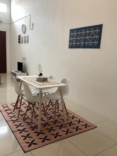a dining room table and chairs on a rug at D' Ara SZ Homestay in Kubang Semang