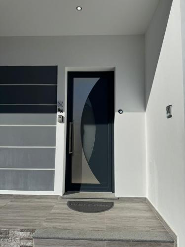 a black door on a white wall with a wooden floor at Charming Holiday Home with Free Private Parking in Machico