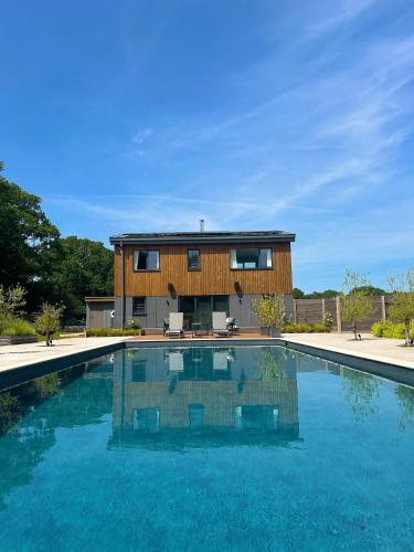 a house with a swimming pool in front of a house at Large Heated Pool with Countryside Views in Cowfold