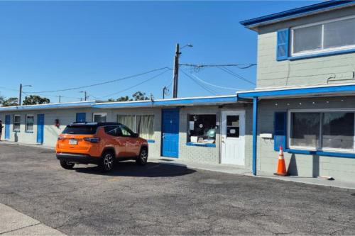 an orange car parked in front of a building at Base Motel By OYO South Tampa in Tampa