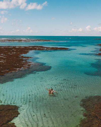 a person swimming in the water in the ocean at Casa Amaré - Moreré in Moreré