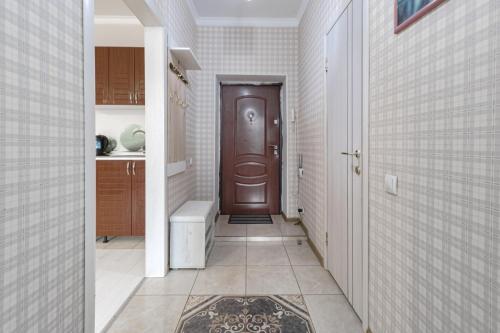 a hallway with a wooden door in a kitchen at Уютная квартира рядом с Батырмол и Баянтау in Pavlodar
