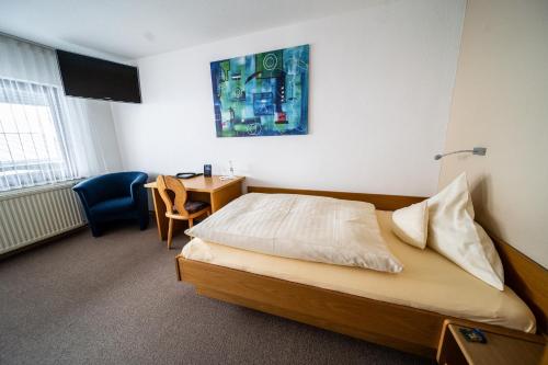 ein Hotelzimmer mit einem Bett, einem Schreibtisch und einem Stuhl in der Unterkunft Hotel Rieder in Wiesemscheid