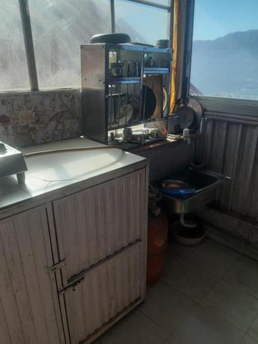 cocina con encimera, fregadero y ventana en Aashiyana Studio Homestay, en Solan