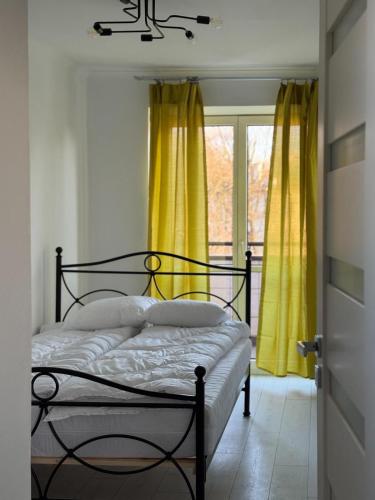 una camera da letto con un letto con tende gialle e una finestra di Przytulny a Bielsko-Biała