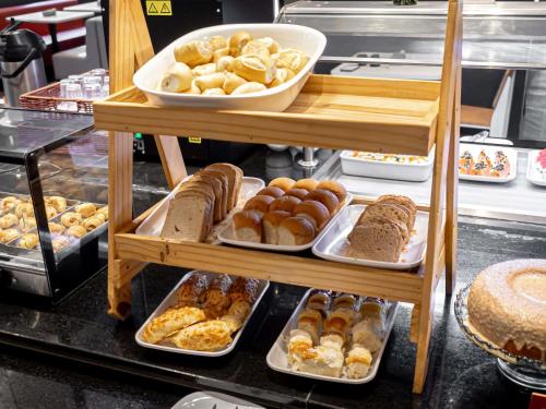 una estantería con diferentes tipos de pan y repostería en ibis Macae, en Macaé