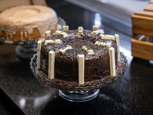 Un pastel de chocolate con velas sobre una mesa. en ibis Macae, en Macaé