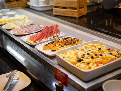 Una línea de buffet con muchos tipos diferentes de comida. en ibis Macae, en Macaé