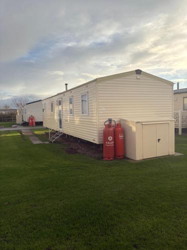 a mobile home with two fire hydrants in a yard at TLJ Caravan Hires in Mablethorpe