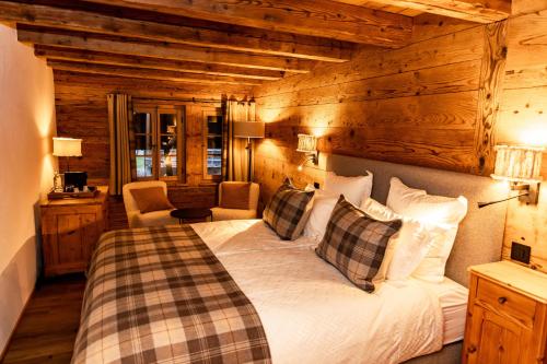 una camera da letto con un letto in una stanza con pareti in legno di Au 17 Chambre d'hôtes, Rte du Village 17, 1875 Morgins a Troistorrents