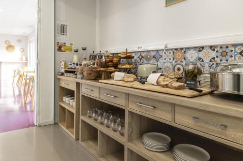 a kitchen with a counter with bread and other foods at Appart Hotel Odalys City Metz Manufacture in Metz
