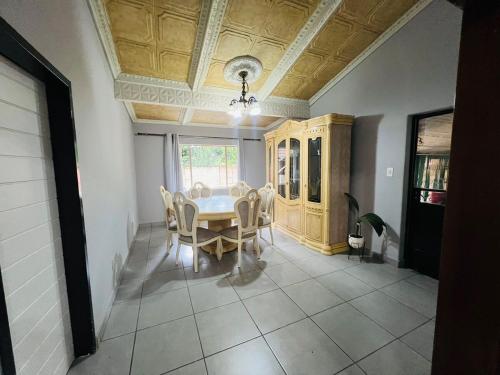 een eetkamer met een tafel en stoelen bij Chic 3-bed home with comfort in Pretoria