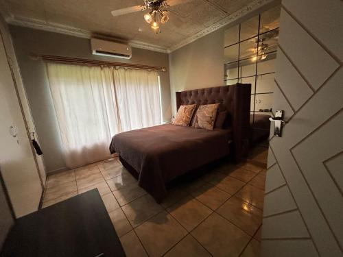 een kleine slaapkamer met een bed en een raam bij Chic 3-bed home with comfort in Pretoria