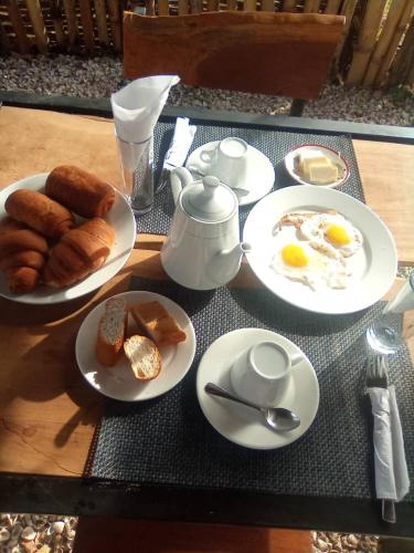 ein Tisch mit Tellern mit Eiern und Gebäck darauf in der Unterkunft FARAFINA KEUR DAMEL Toubakouta in Toubakouta