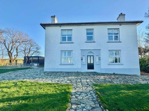 阿姆奇Luxury coastal retreat with sea views的一栋有石头车道的白色大房子