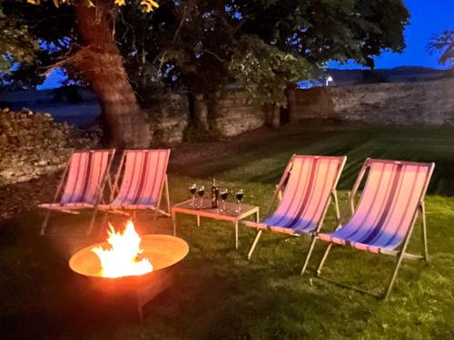 阿姆奇Luxury coastal retreat with sea views的院子里有两把椅子和一张桌子,火炉