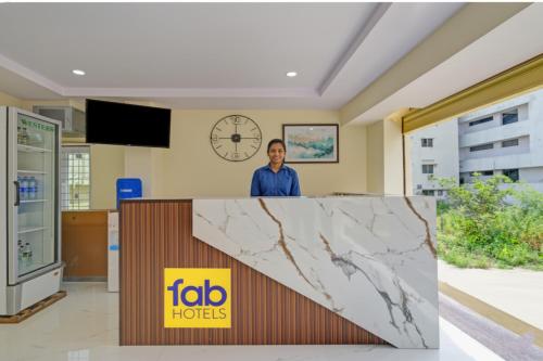a man standing behind a counter with a marble counter top at FabHotel Srikara Grand Luxury Rooms in Hyderabad