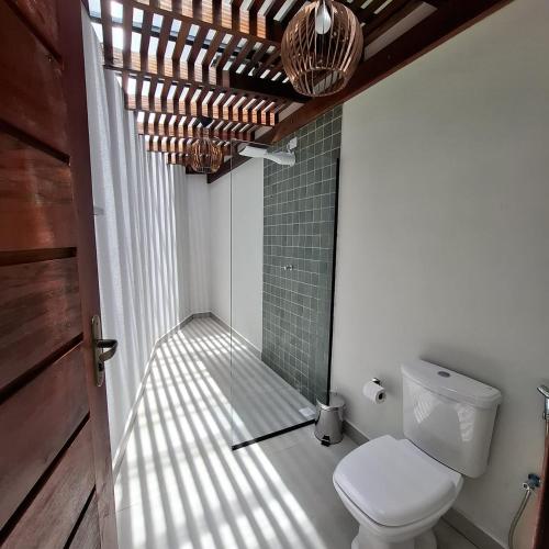ein Badezimmer mit Toilette und Fenster in der Unterkunft Reale Paraty in Paraty