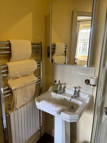 a bathroom with a sink and a mirror and towels at The Brontë Birthplace in Thornton