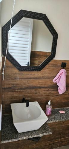a bathroom sink with a mirror on a counter at Chácara do Juscelino in Monte Sião