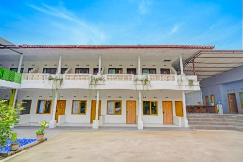 ein großes weißes Gebäude mit Bäumen davor in der Unterkunft Collection O Subang near Ciater Subang formerly Orchid Villa Ciater in Ciater