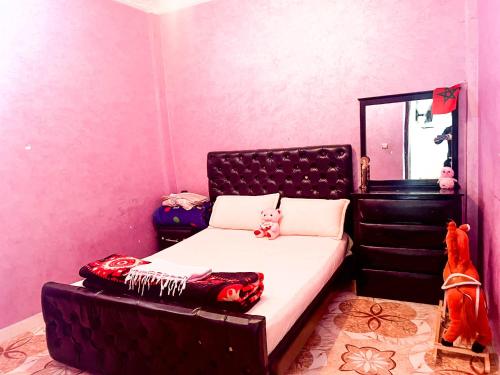 塔哈佐特Azazoul Apartment Taghazout的卧室里有一张带黑色床头板的床