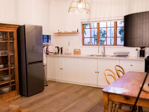 a kitchen with a black refrigerator and a table at OLYF accommodation in Bloemfontein