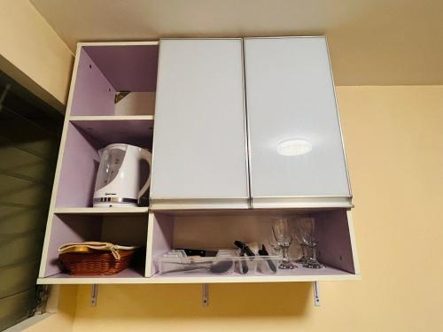 a cabinet with white cabinets in a kitchen at JOs HOMEtel at Heritage City of the South Carcar in Guinauayan