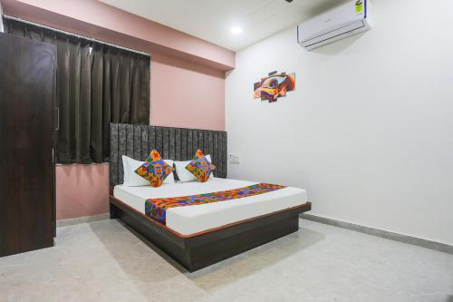 a bedroom with a bed with colorful pillows at Hotel Brook View in Surat