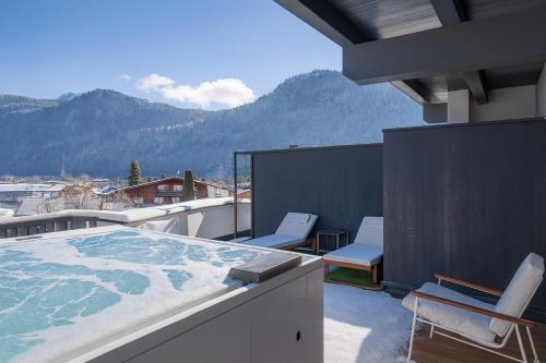 a balcony with chairs and a hot tub on a roof at PENTHOUSE N`4 - AlpenLuxus Collection in Kramsach