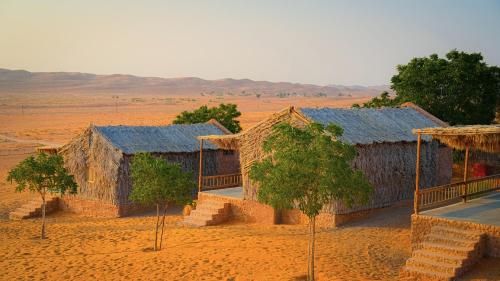 un grupo de chozas en medio de un desierto en SAMA Al Areesh Desert Camp, en Al Qābil