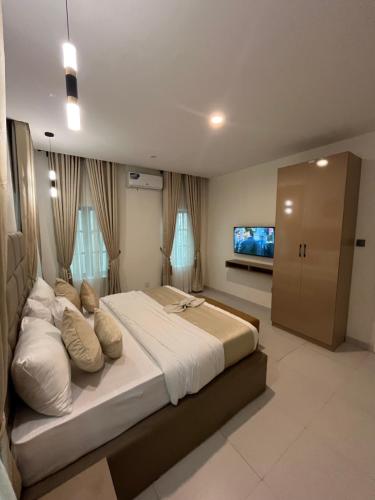 una grande camera con un grande letto e una TV a schermo piatto di Sweet Home hotel a Lekki
